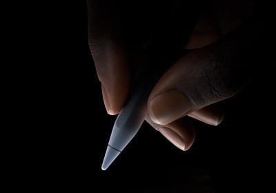 ユーザーが親指と人差し指でApple Pencil Proの下3分の1部分を持ち、書こうと構えている。